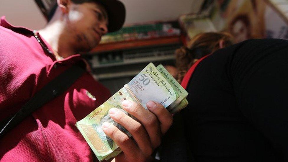 Man holding Venezuelan bolivars