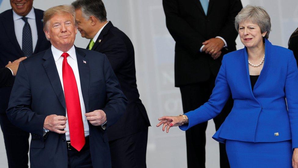 U.S. President Donald Trump and Britain"s Prime Minister Theresa May react as NATO leaders pose for a family photo at the start of the NATO summit in Brussels, Belgium July 11, 2018.