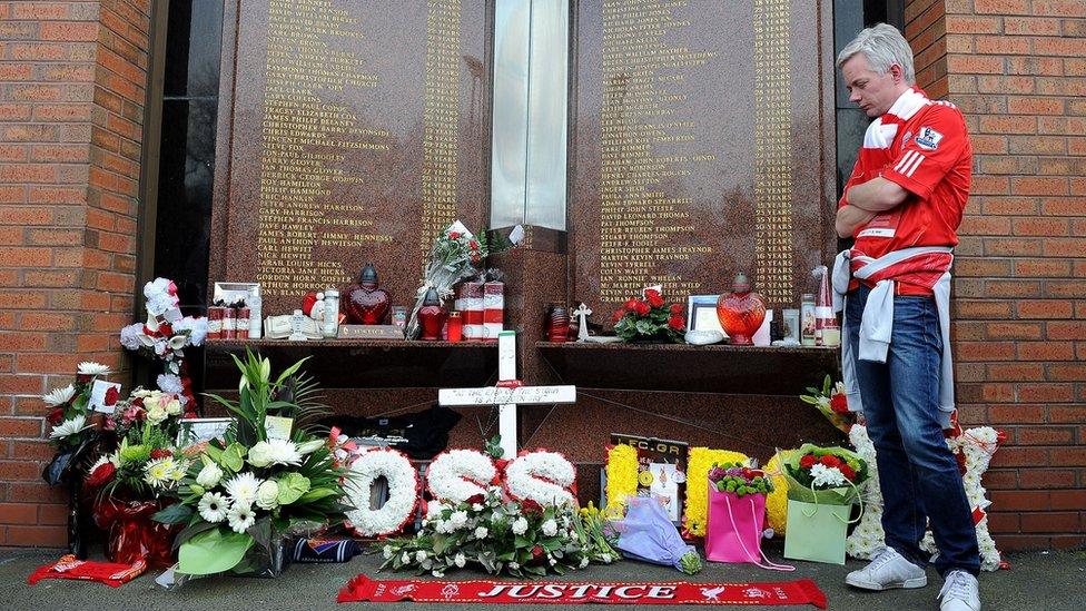 A Liverpool fan looks at tributes at the Hillsborough memorial at Liverpool's Anfield stadium.