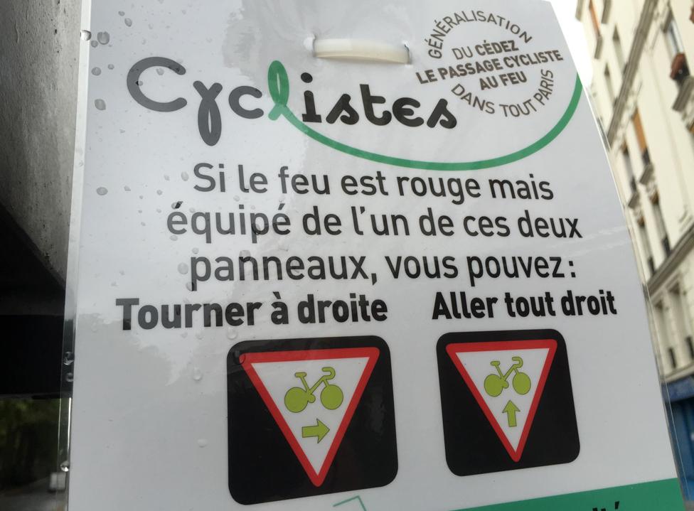 New sign in Paris that reads: "If the light is red but equipped with one of these two panels, you can: Turn right; Go straight on"