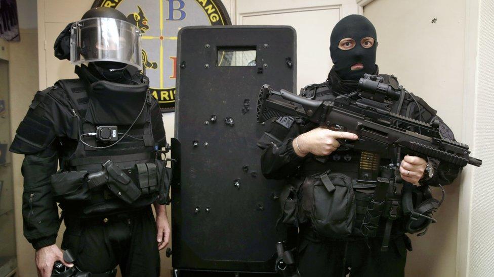 French police commandos of the Search and Intervention Brigade (BRI - Brigade de recherche et d"intervention) pose with a bullet-hole riddled riot shield in Paris on November 17, 2015