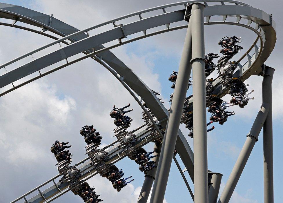 People ride the Swarm rollercoaster