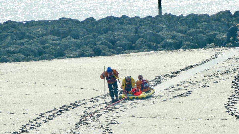 Rescuers using a sled to rescue the family