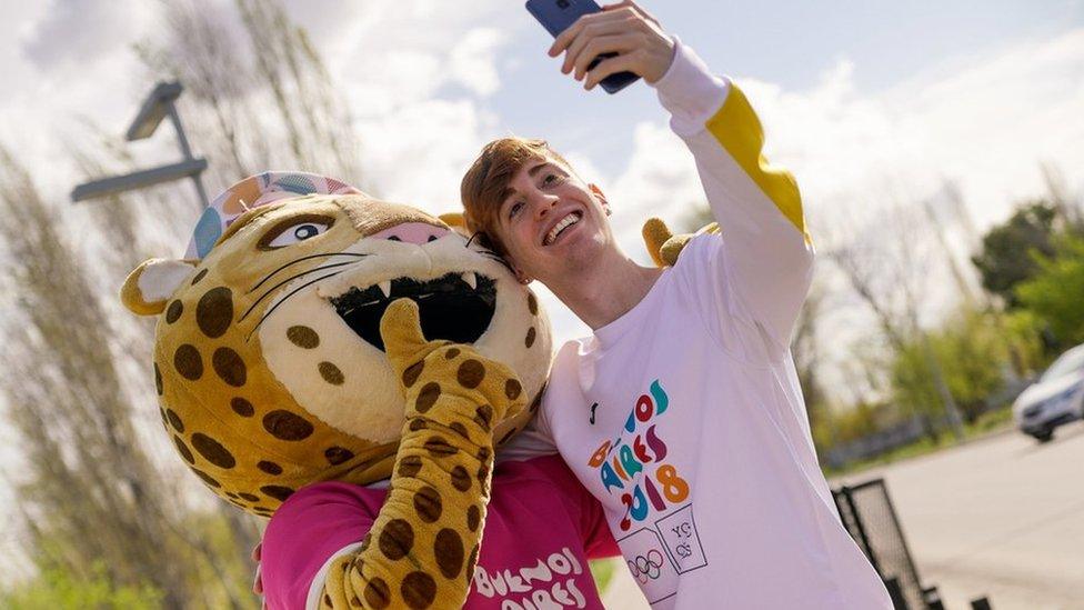 A picture of the mascot with a fan, taken on the torch's tour around the country.