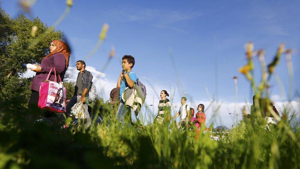 Migrants walk to be registered after crossing the border from Austria in Freilassing, Germany