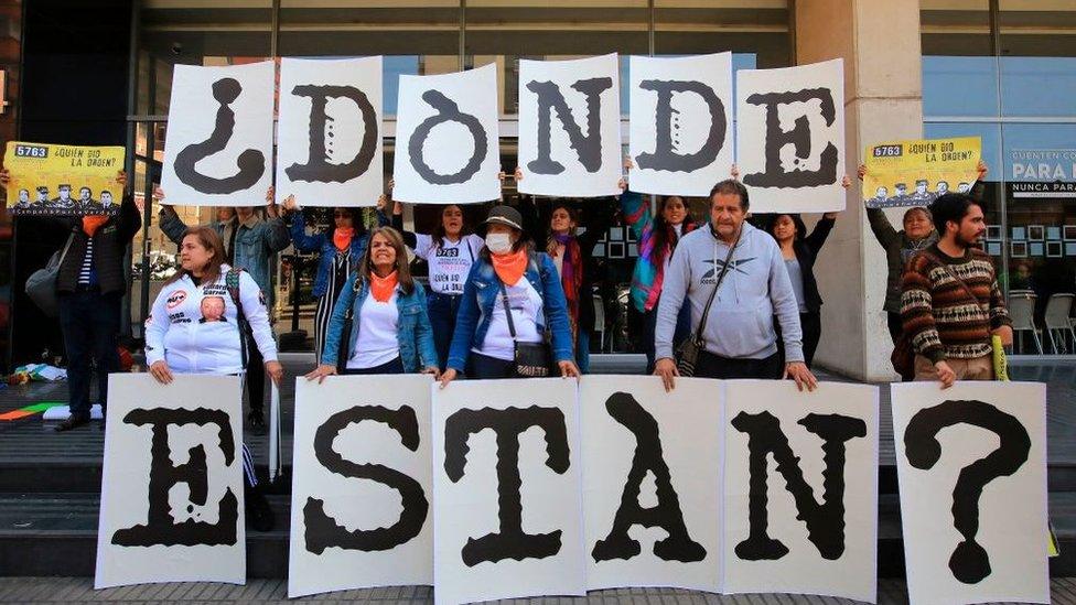 People form the question "Where Are They" as they demonstrate against the "false positives", executions of civilians at the hands of the military who presented them as combat casualties to swell results of the armed conflict, in front of the Special Jurisdiction for Peace in Bogota, on February 12, 2020