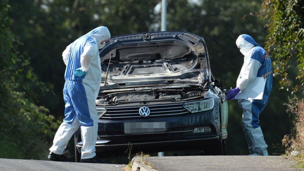 Forensic officers examine a vehicle believed to be linked to the incident