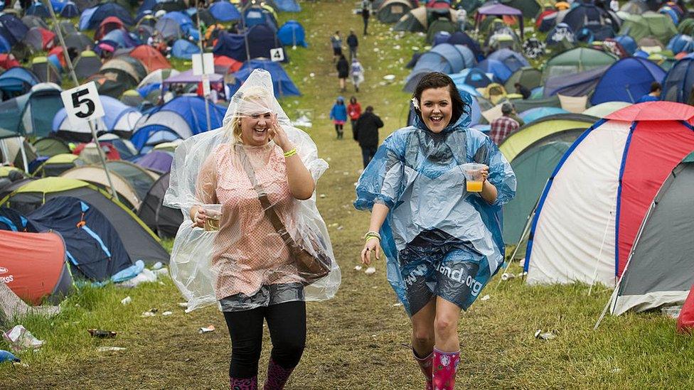 Women with ponchos on at a festival