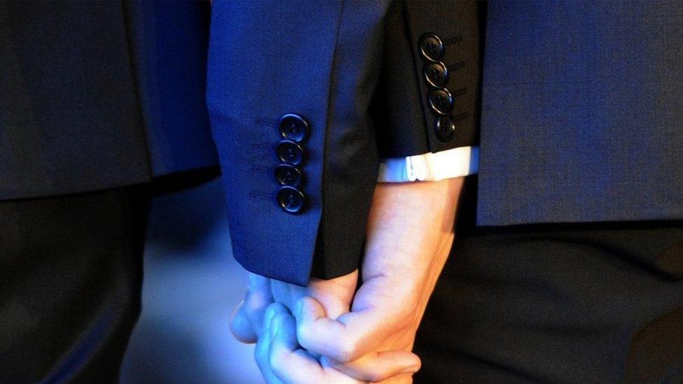 Two men holding hands