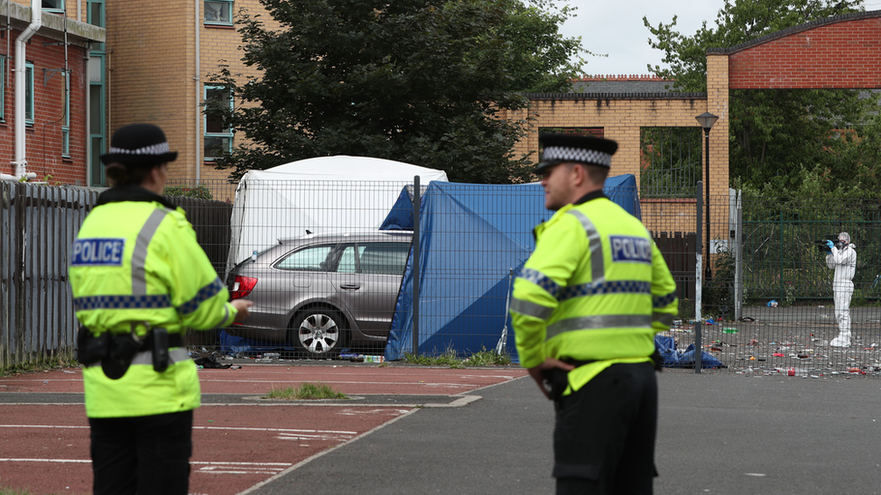 Police outside a white tent at the shooting location