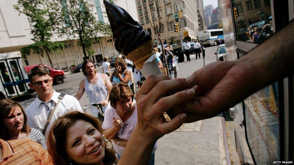 An ice cream cone is handed to a woman