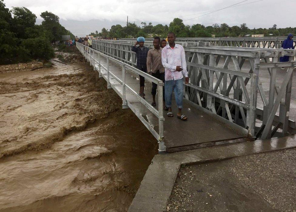 People cross a bridge while Hurricane Matthew passes in Port-au-Prince, Haiti, on October 4, 2016.