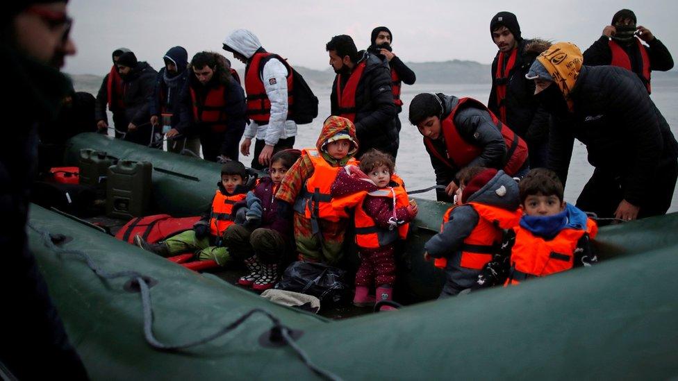 Migrants with children get on an inflatable dinghy, as they leave the coast of northern France to cross the English Channel, near Wimereux, France. File photo