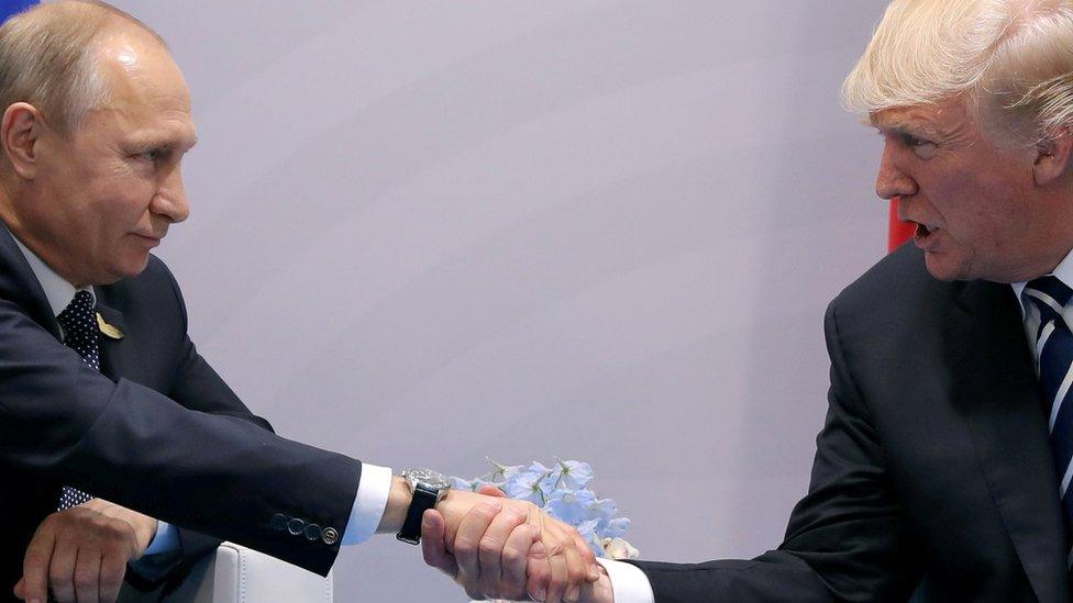 Vladimir Putin shaking hands with Donald Trump