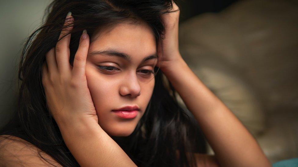 Woman who is tired and holding her head