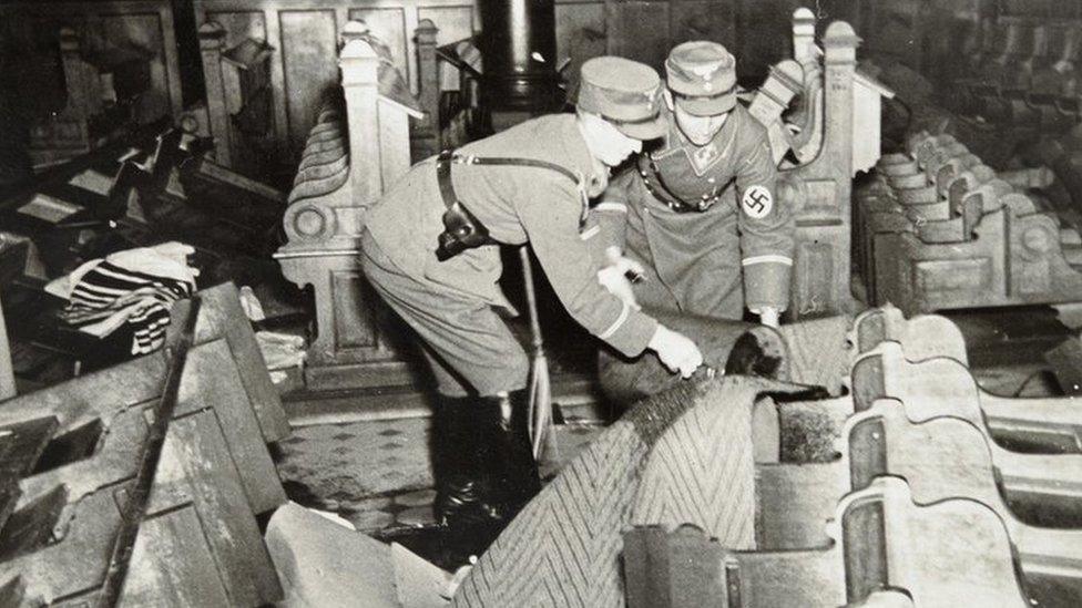 German forces pouring petrol onto pews at a synagogue