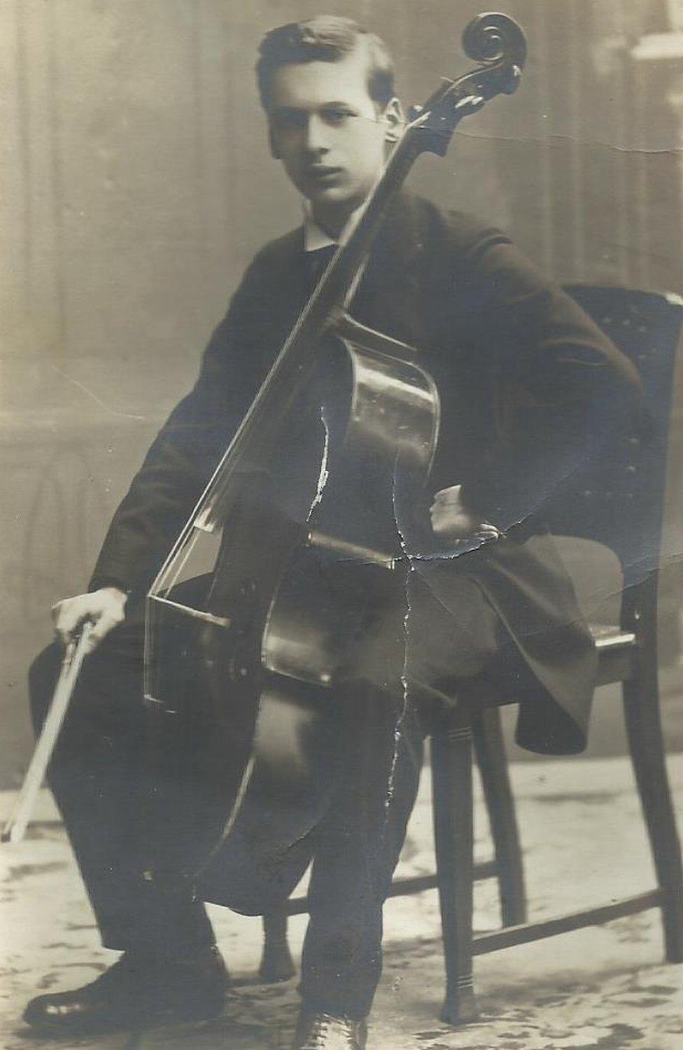 An aged and slightly crumpled photograph of Fritz Ball playing cello