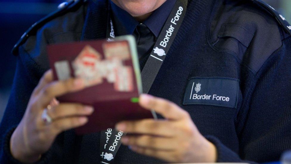 Border Force officer checking passport