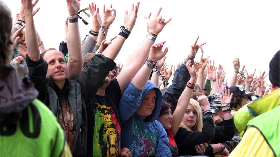 Crowd members "throwing horns"