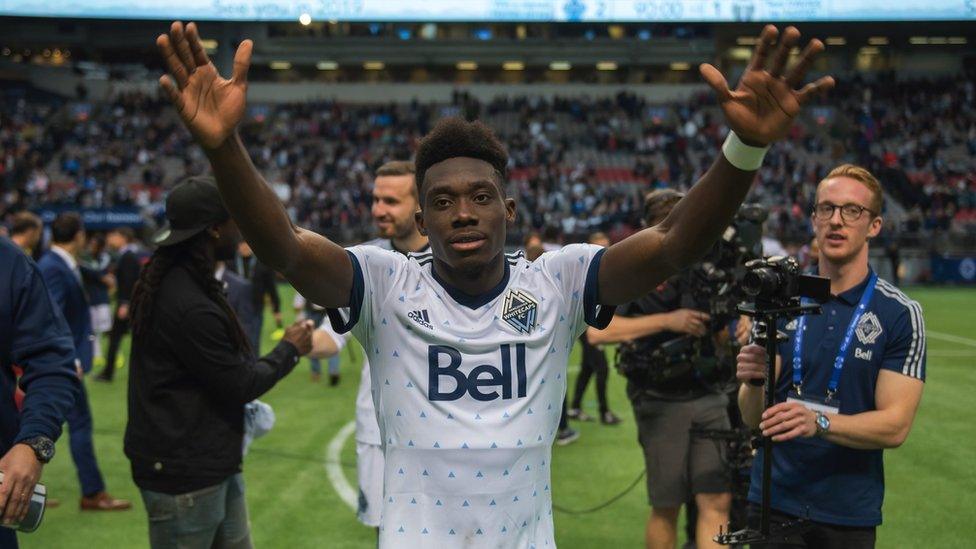 Alphonso Davies holding up arms after a MLS football match