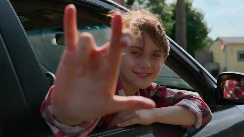 Girls signing in ASL from a car window