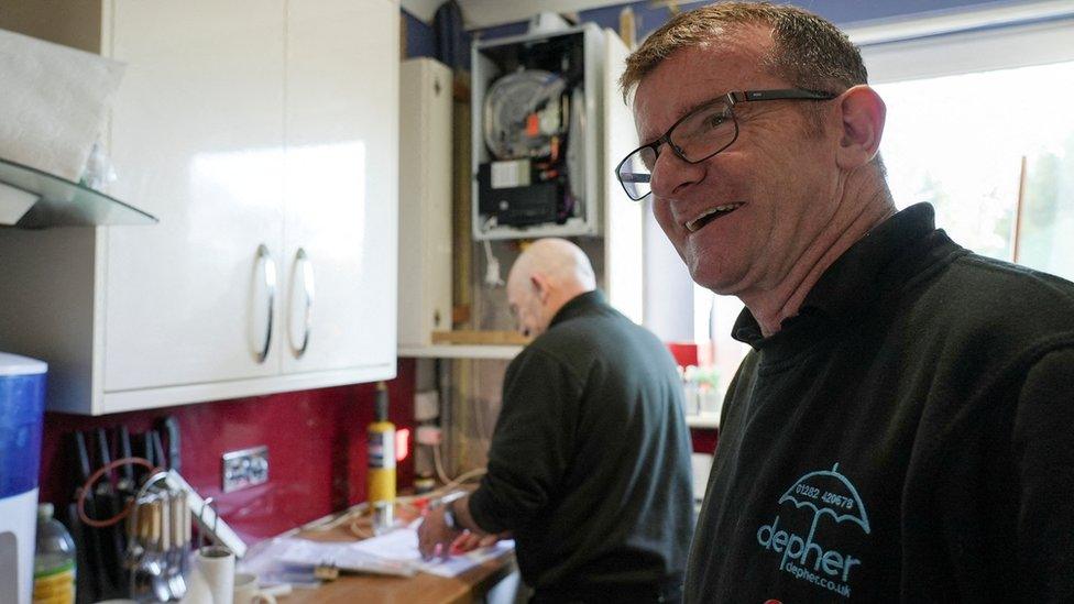 James Anderson and a plumber at work