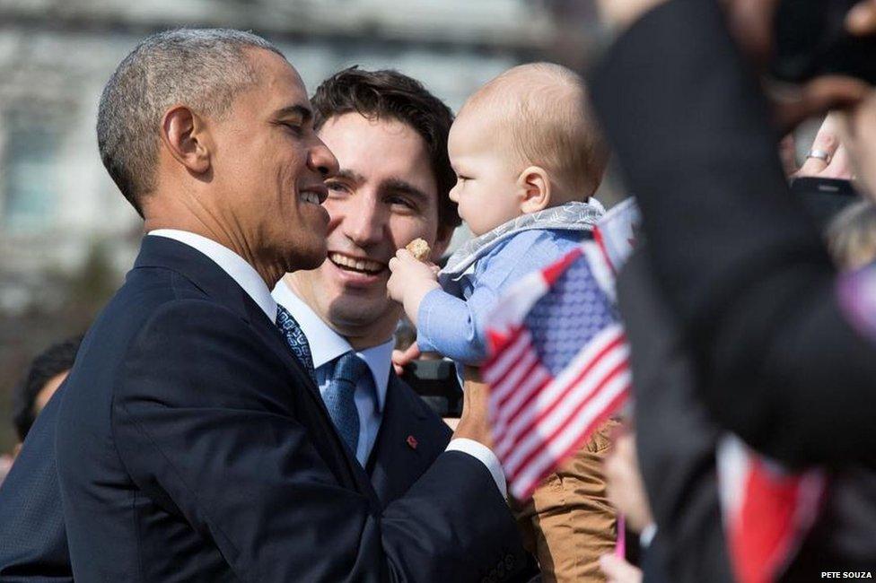 Mr Obama and Mr Trudeau smile at baby as they greet visitors to the White House