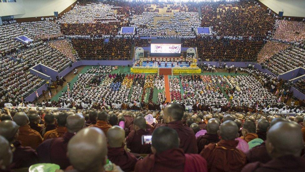 Buddhist monks and supporters celebrate in a stadium at Yangon on Sunday