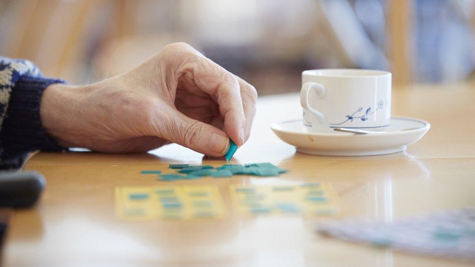 Old person's hand and cup - stock photo