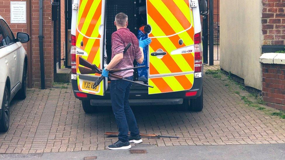 Guns being loaded into a police van