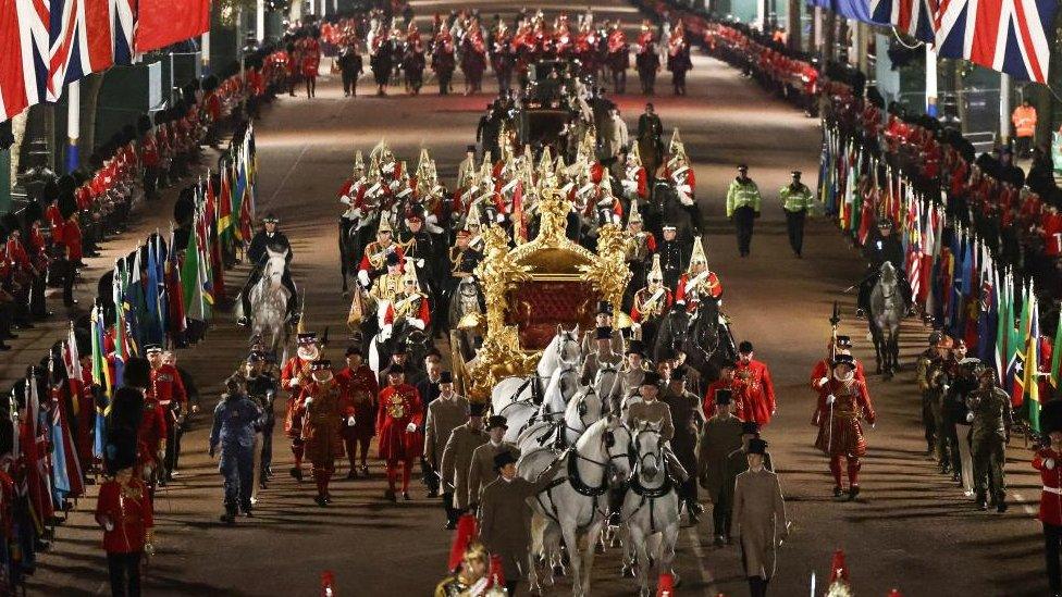 The Gold State Coach is ridden alongside members of the military