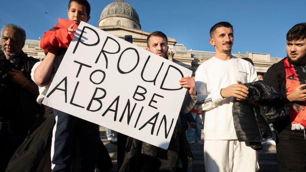 Albanians carry a placard reading 'Proud to be Albanian'