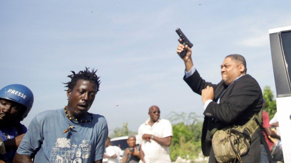 Senator Jean Marie Ralph Féthière holds a gun in the country's capital, Port-au-Prince