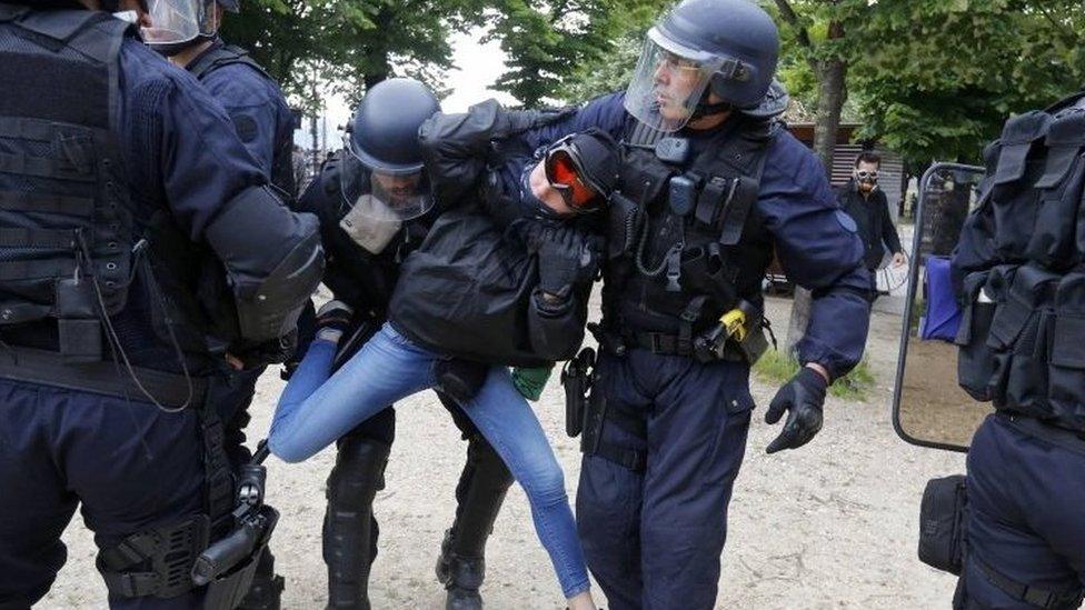 French CRS riot police apprehend a demonstrator during clashes at the Invalides square during a demonstration in Paris as part of nationwide protests against plans to reform French labour laws.