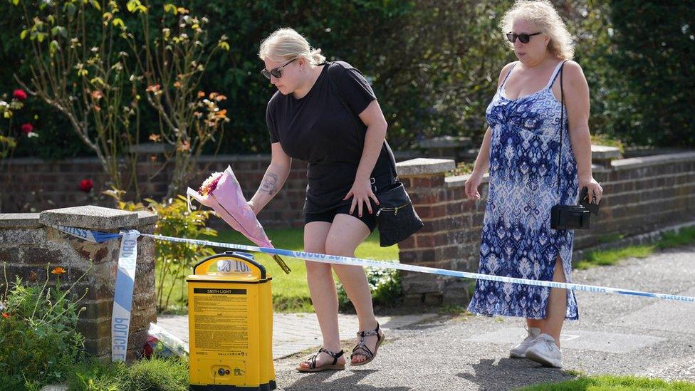 Public lay flowers at scene