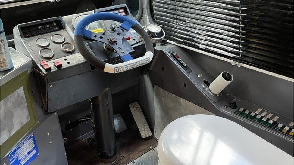 Driver's cab of a bus with the seat replaced by a toilet