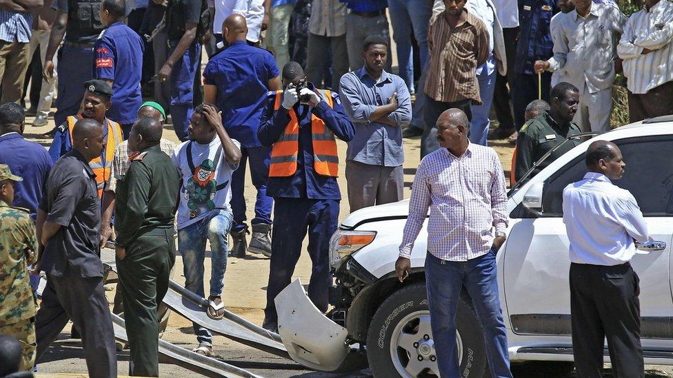 Crowds at the scene of the blast surrounding one white damaged vehicle in Khartoum, Sudan - 9 March 2020