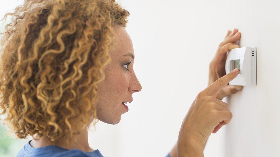 Woman checking thermostat