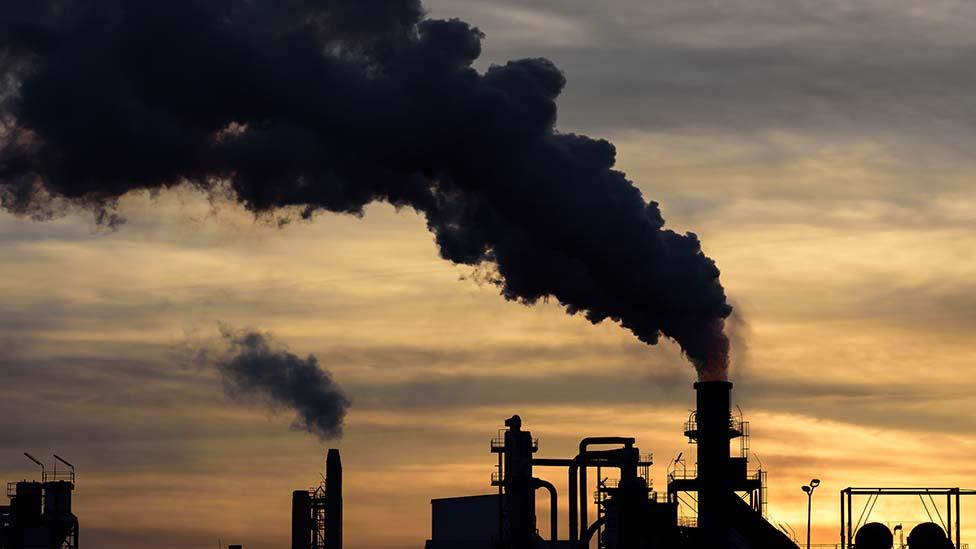 Black cloud billowing out from industrial chimney