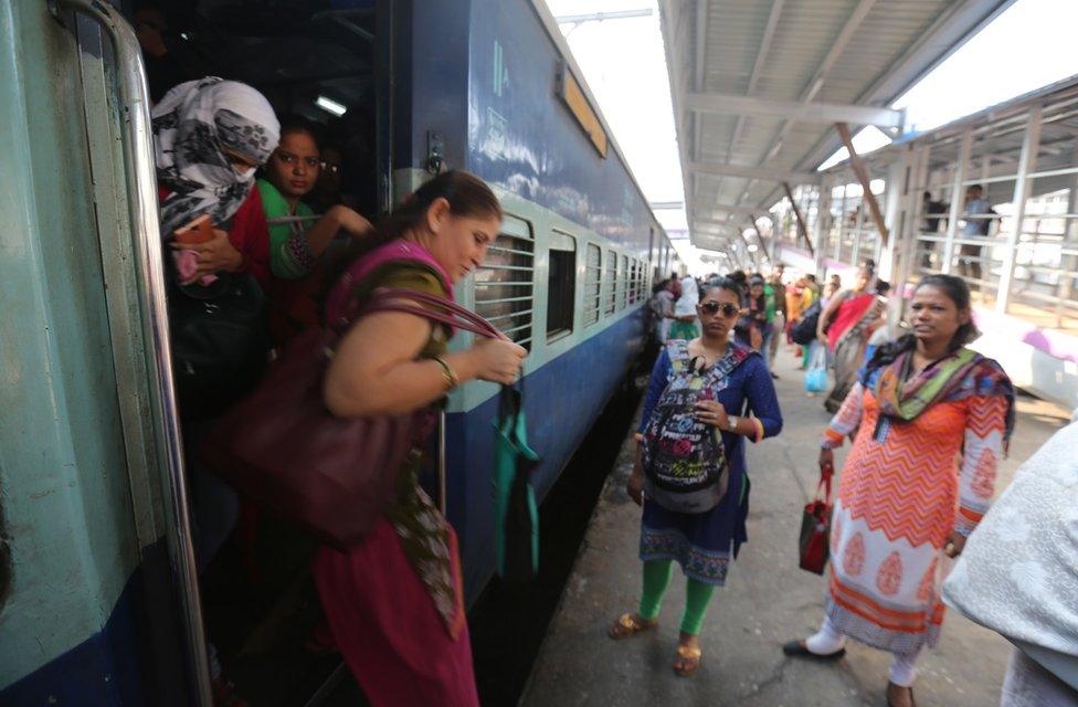 People mind the gap as they get off the train at Mumbai