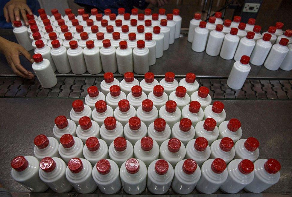 A Chinese worker arranges bottles of quality locally made wine called baijiu at the Guizhou Huaizhuang Liquor Group on 22 September 2016 in Maotai,Guizhou province, China