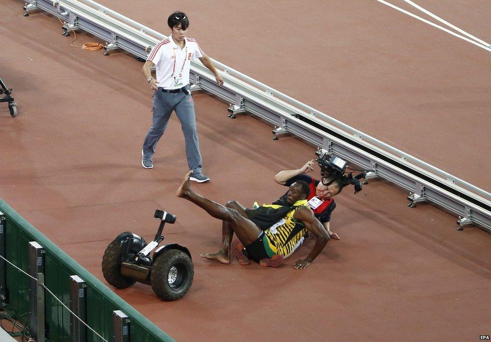 Usain Bolt of Jamaica falls over after a TV cameraman with a segway drove into him after the men"s 200m final during the Beijing 2015 IAAF World Championships at the National Stadium, also known as Bird's Nest, in Beijing, China, 27 August 2015