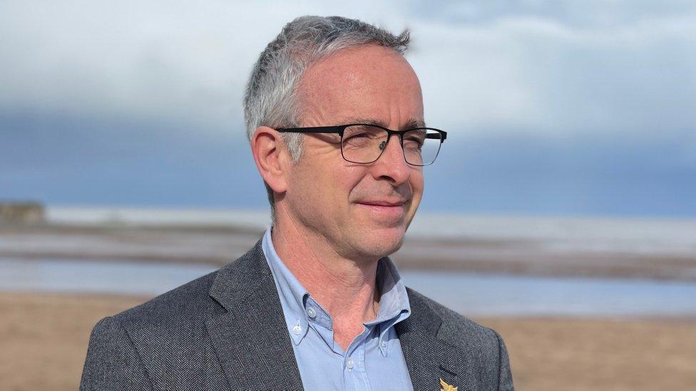 Benet Allen looking into the distance on a beach