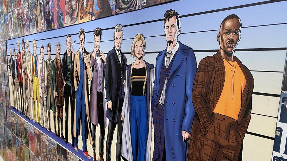 A photo of artwork depicting the actors who have played Dr Who in chronological order