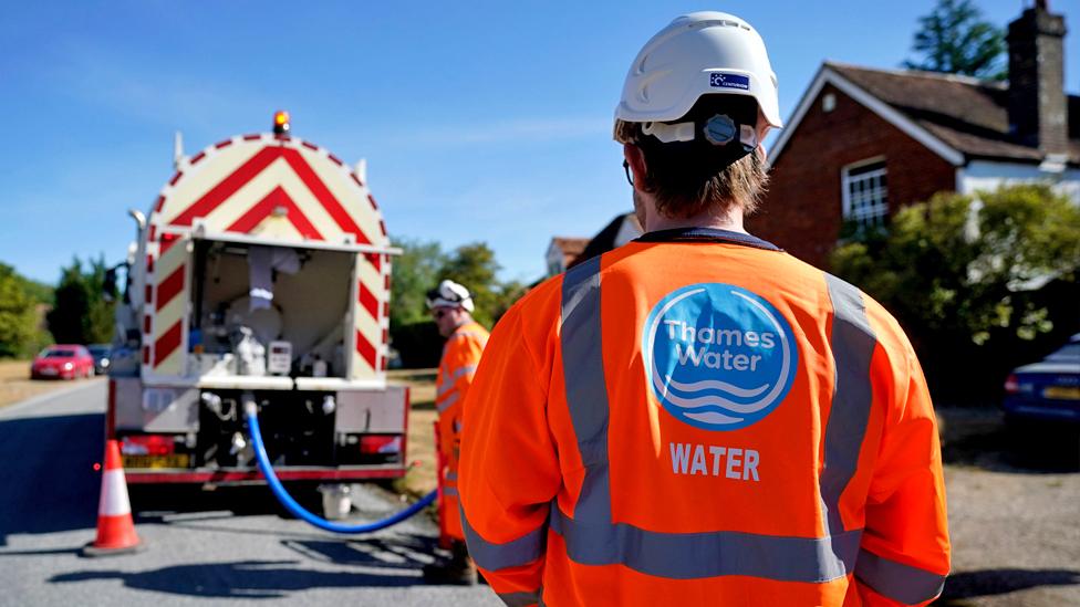 A worker from Thames Water delivering a temporary water supply from a tanker to the village of Northend in Oxfordshire on 10 August 2022