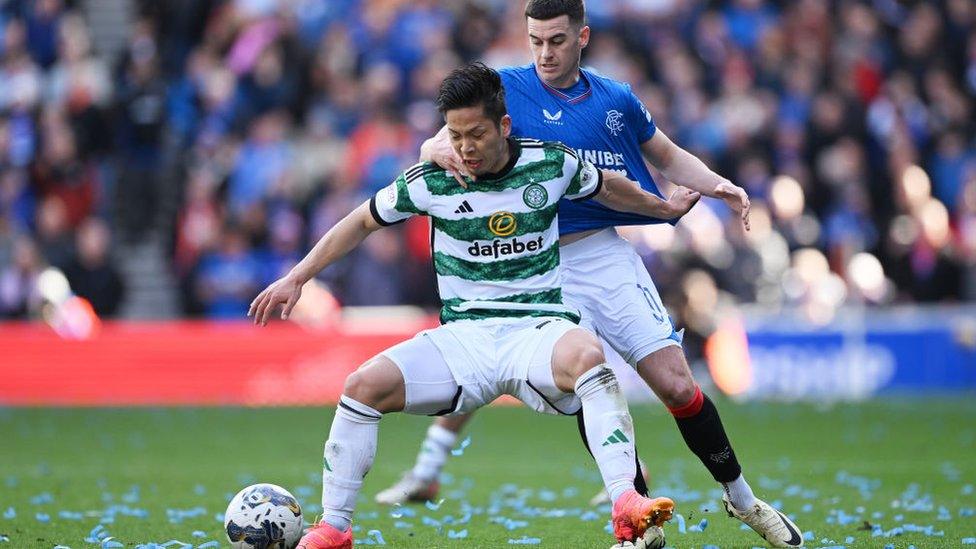 Tomoki Iwata of Celtic battles for possession with Tom Lawrence of Rangers