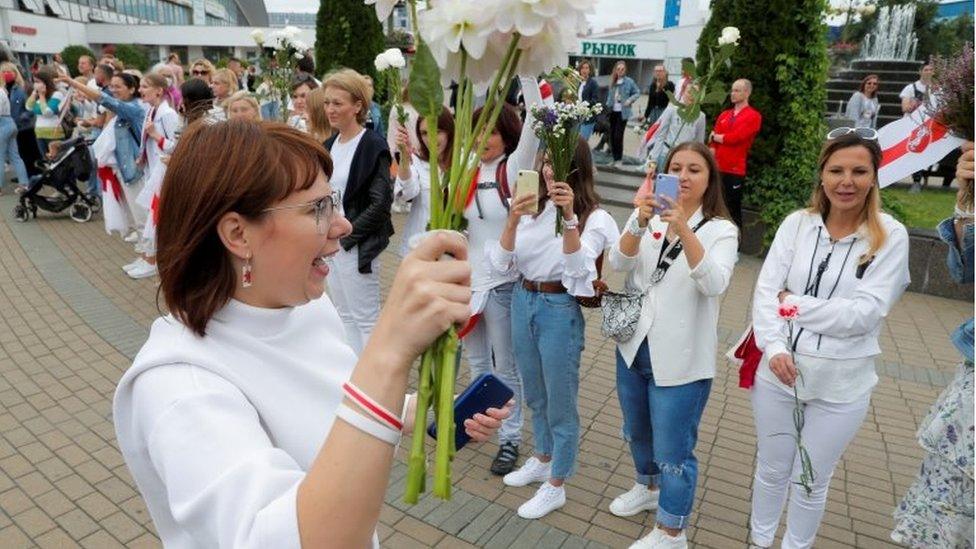 Representative of the Co-ordination Council for members of the Belarusian opposition Olga Kovalkova holds flowers as she attends an opposition demonstration to protest against presidential election results in Minsk, Belarus August 22, 2020.