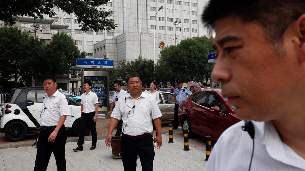 Chinese men in plain clothes, believed to be security personnel, follow journalists in an apparent attempt to affect photo and video coverage outside The No.2 Intermediate People"s Court in Tianjin City, located northeast of Beijing, China, 04 August 2016