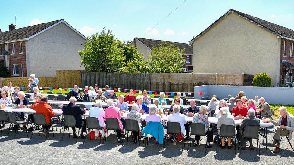 Crowd of people seated at table for street party