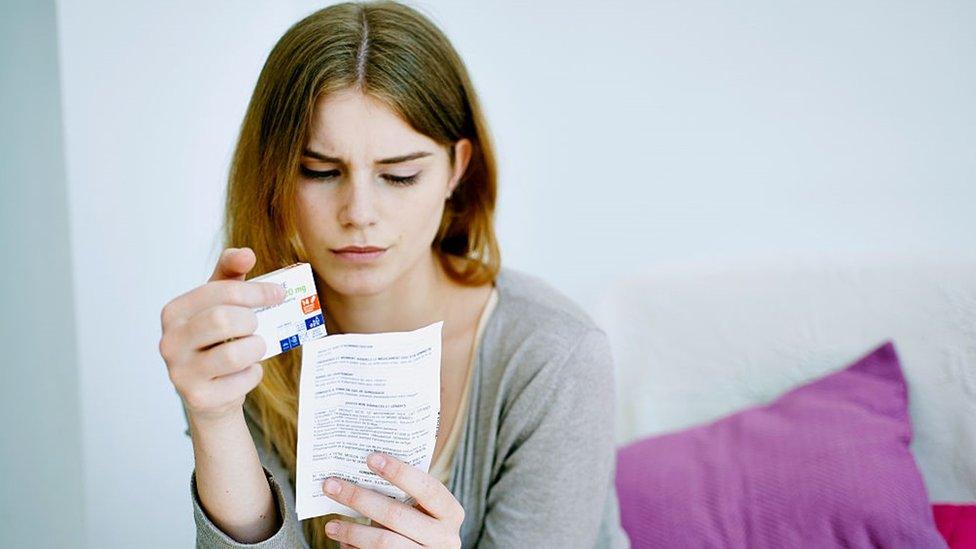 Woman reading paroxetine instruction sheet